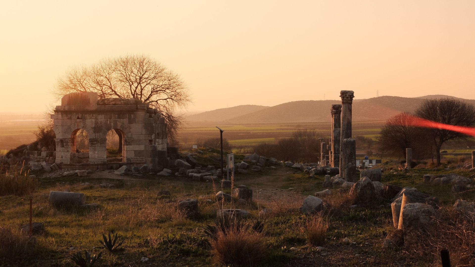 Beautiful view of ancient ruins at sunset in a serene countryside setting.