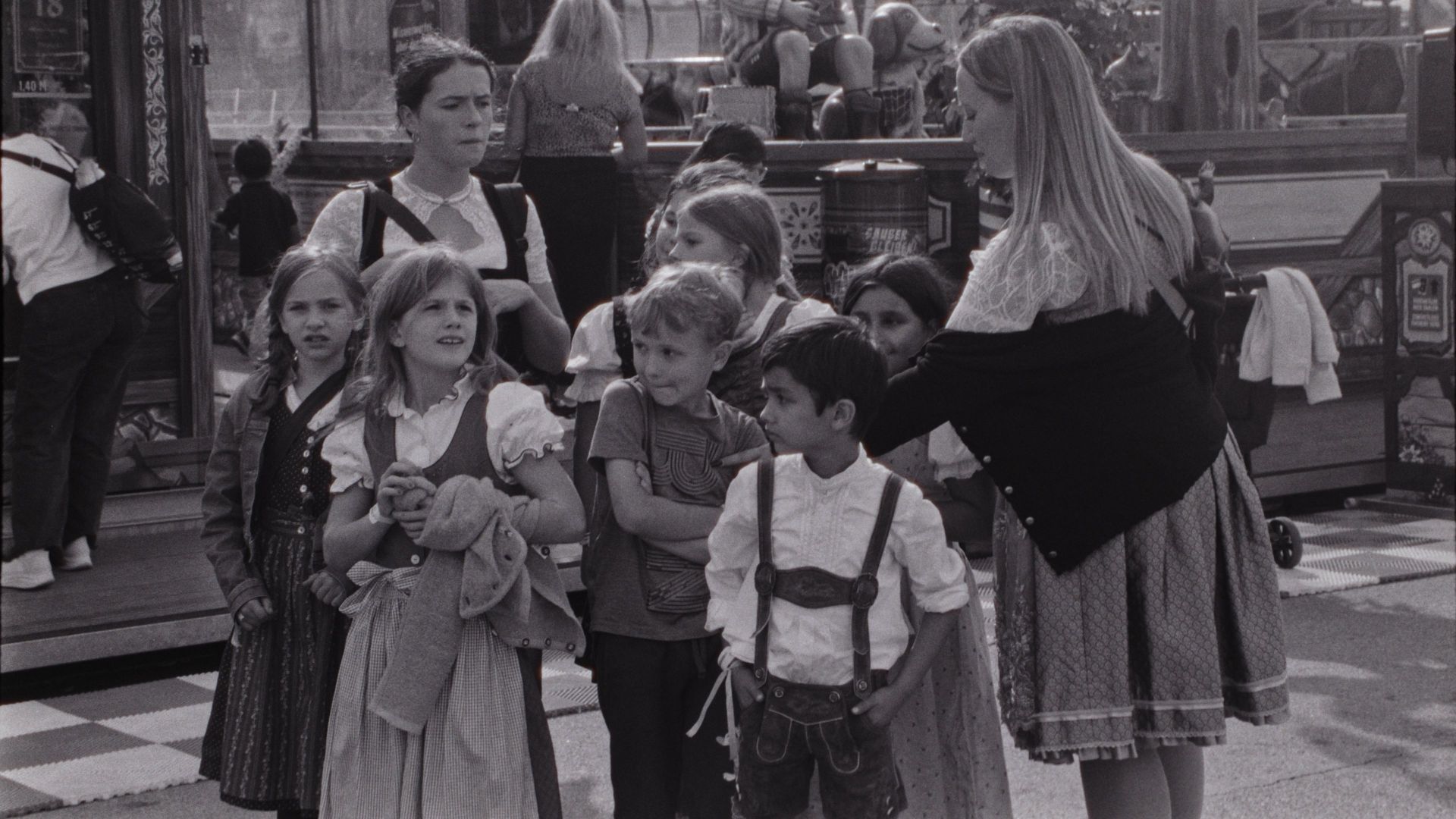 Children and adults in traditional Bavarian costumes at Oktoberfest in Germany.
