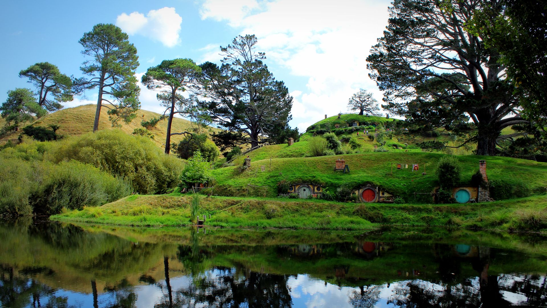 Hobbit holes reflected in water in Hobbiton, Matamata, New Zealand