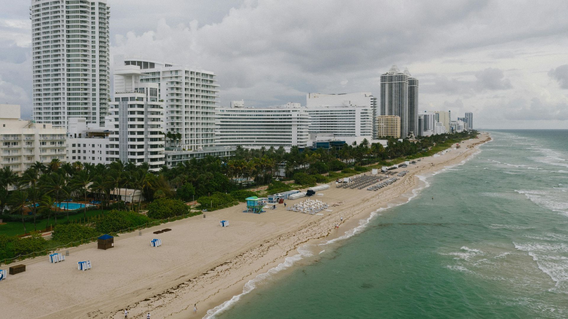 Dramatic aerial photo of a coastal city's modern beachfront skyline in cloudy weather.