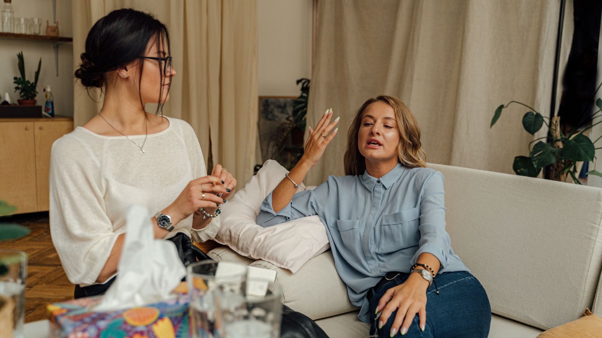 A counseling session with two women engaged in conversation on a comfortable sofa.