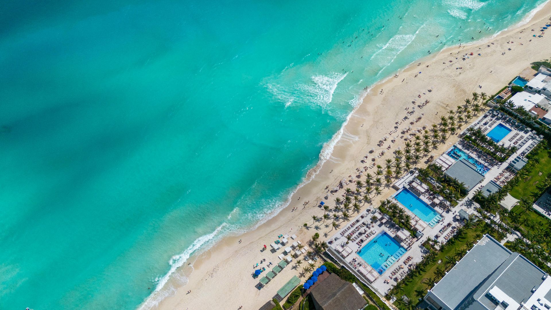 Stunning top view of a Cancun beach resort with turquoise water and sandy shore.