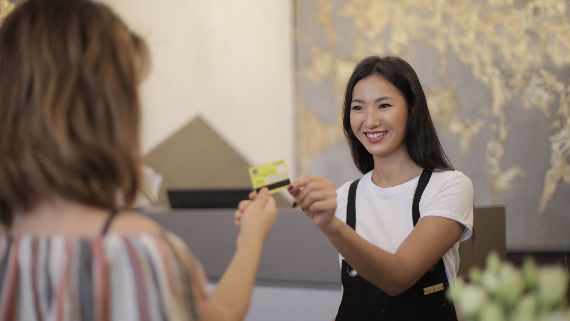 Florist smiling while accepting payment in a flower shop.