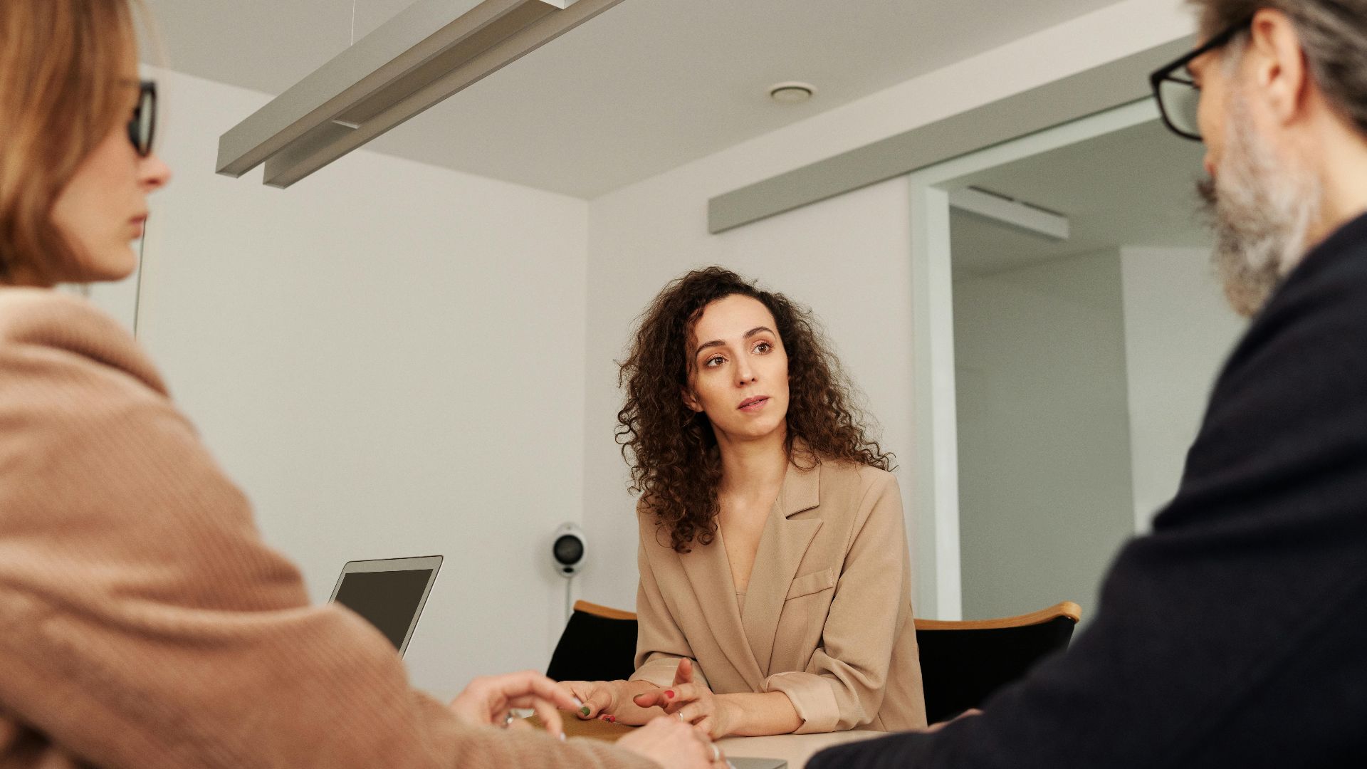 Professionals engage in a focused discussion during a business meeting in a modern office setting.