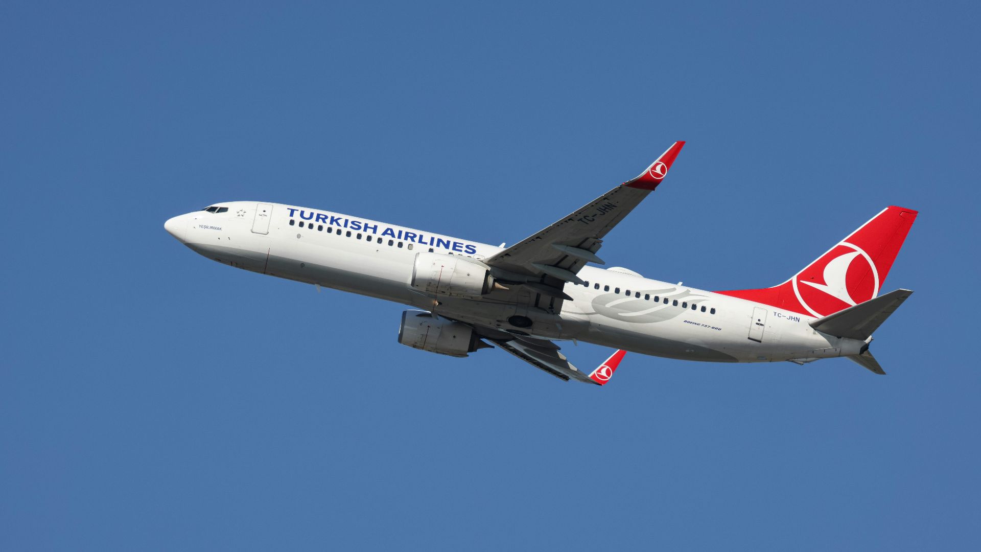 A large jetliner flying through a blue sky