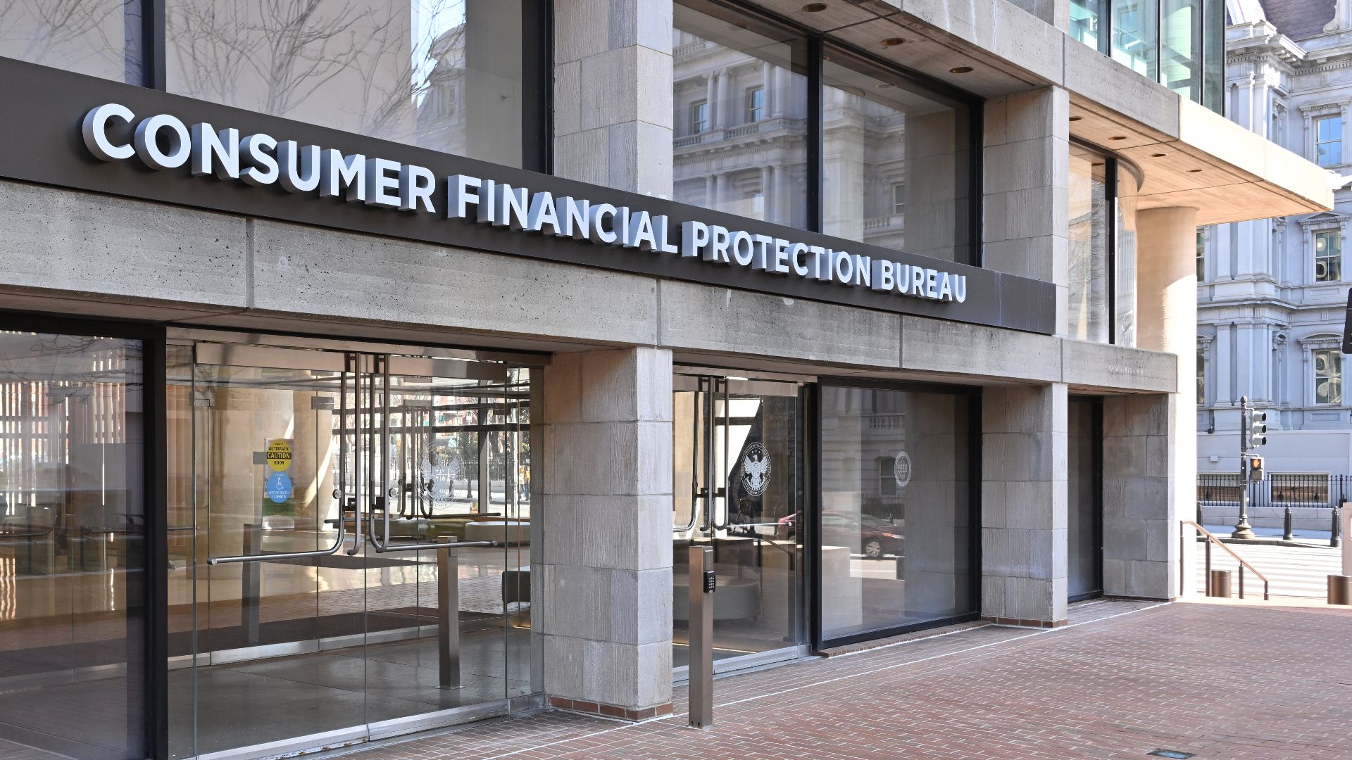 The entrance to the Consumer Financial Protection Bureau headquarters with the bureau's name above it. 1700 G Street NW, Washington, DC 20552.