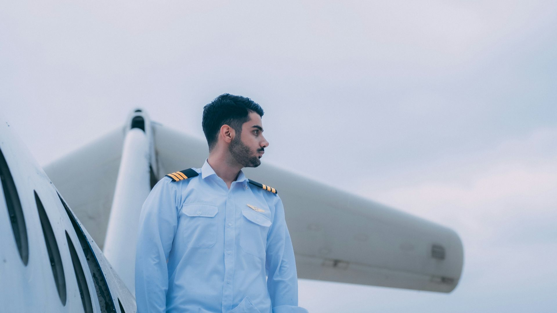 a man in uniform standing next to a plane