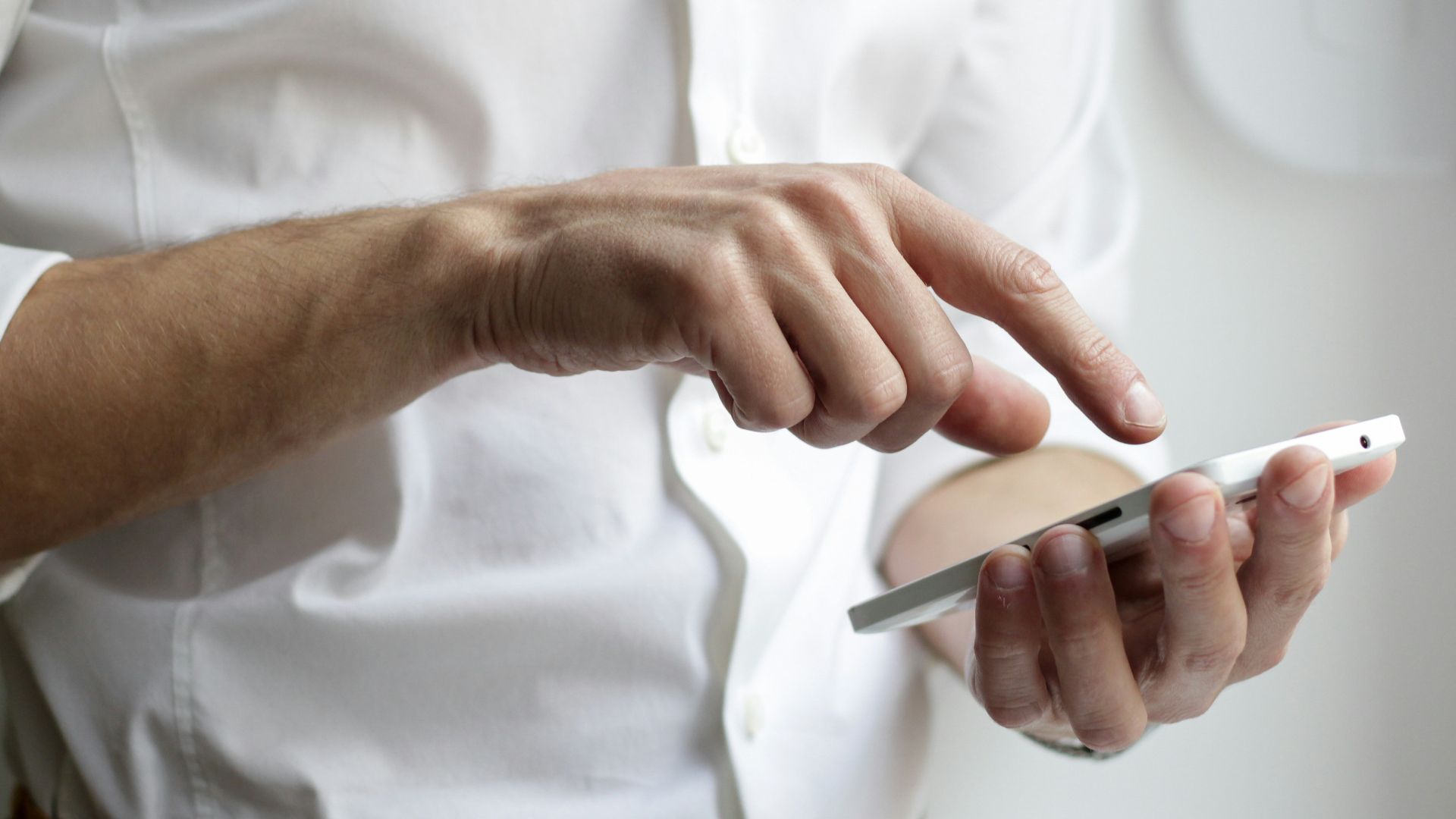 person holding white Android smartphone in white shirt