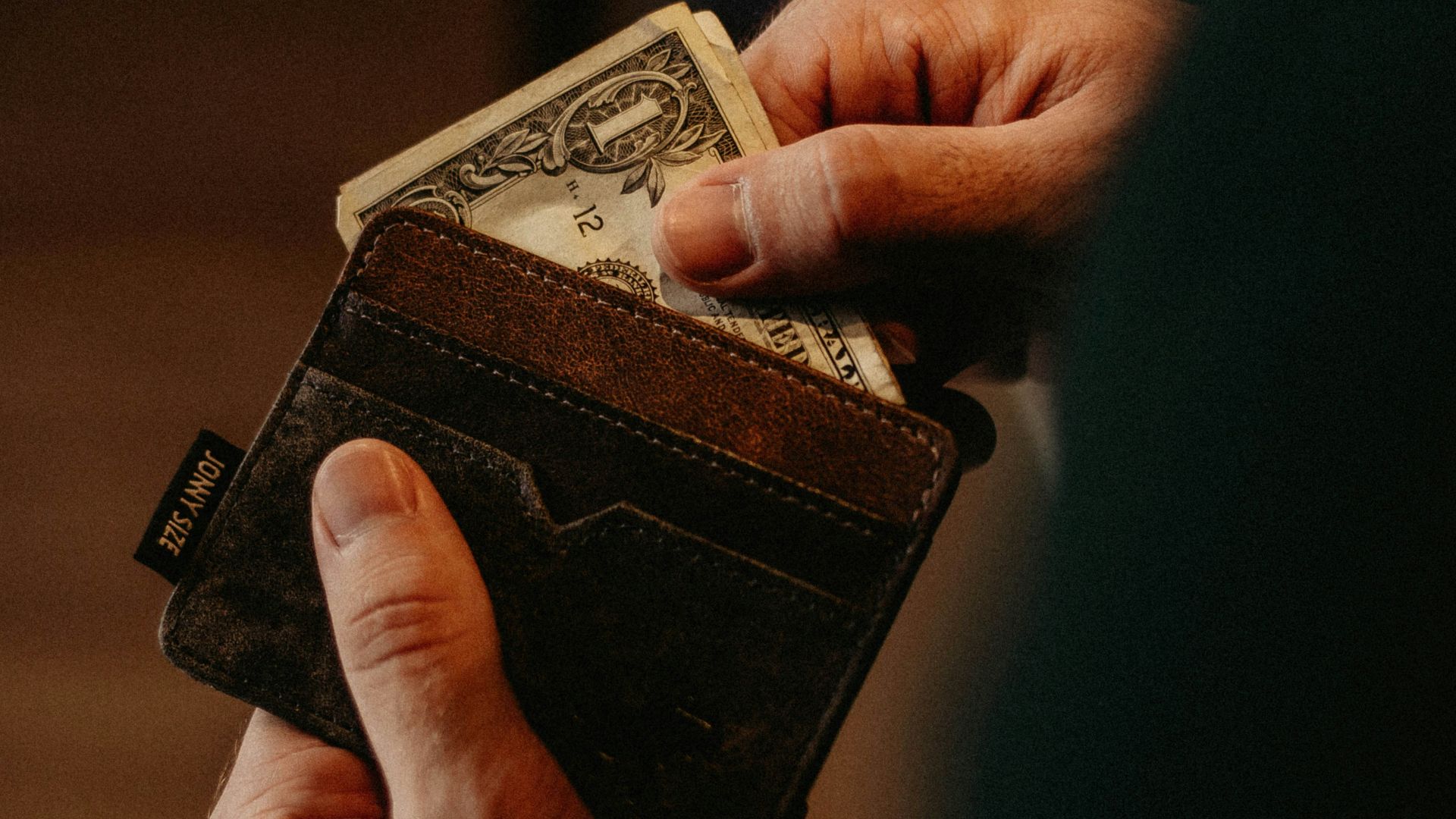 person getting 1 U.S. dollar banknote in wallet
