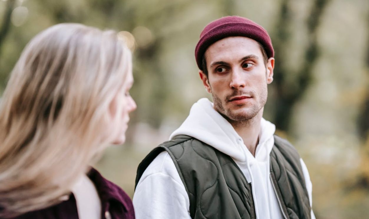 A young couple enjoying a peaceful walk in an urban park during daylight.