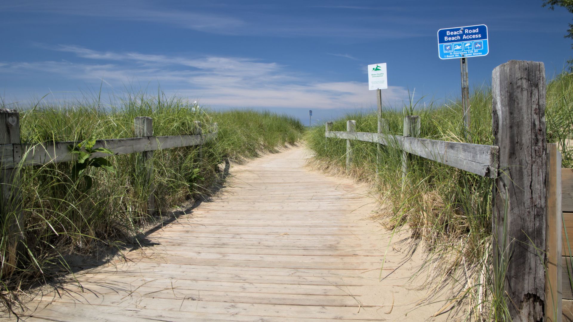 A sunny wooden path through dunes leads to Southampton Beach in Ontario, Canada.