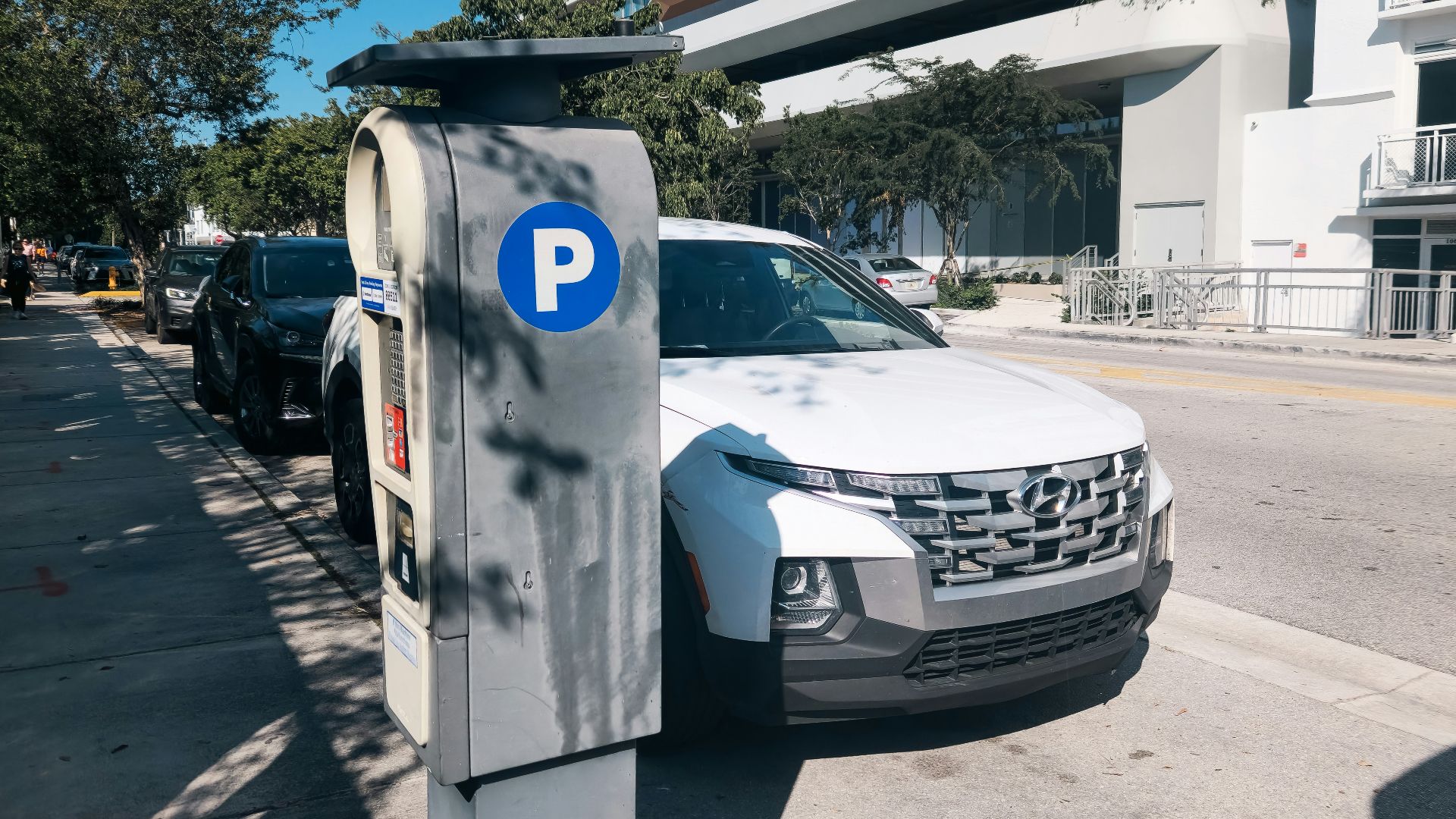 A car parked on the side of a street next to a parking meter