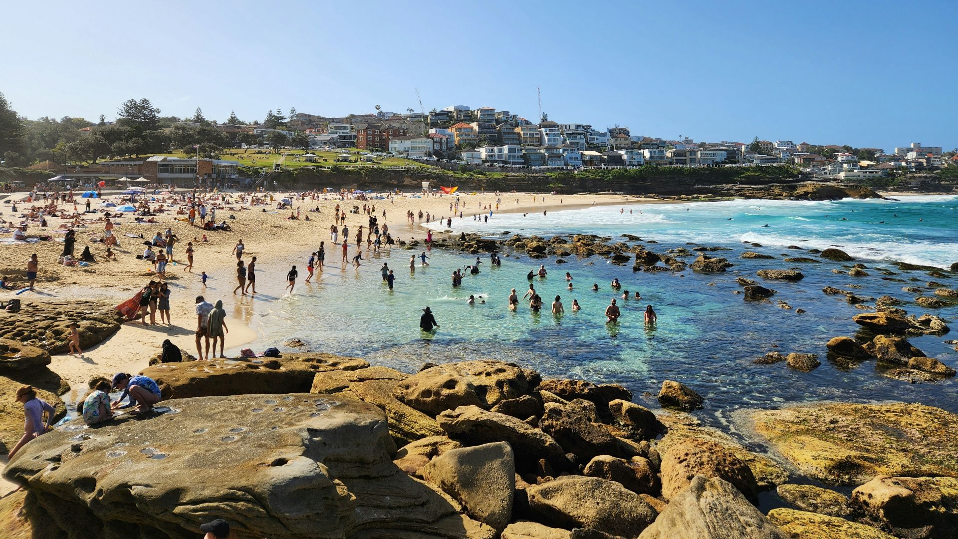 a crowded beach with lots of people on it