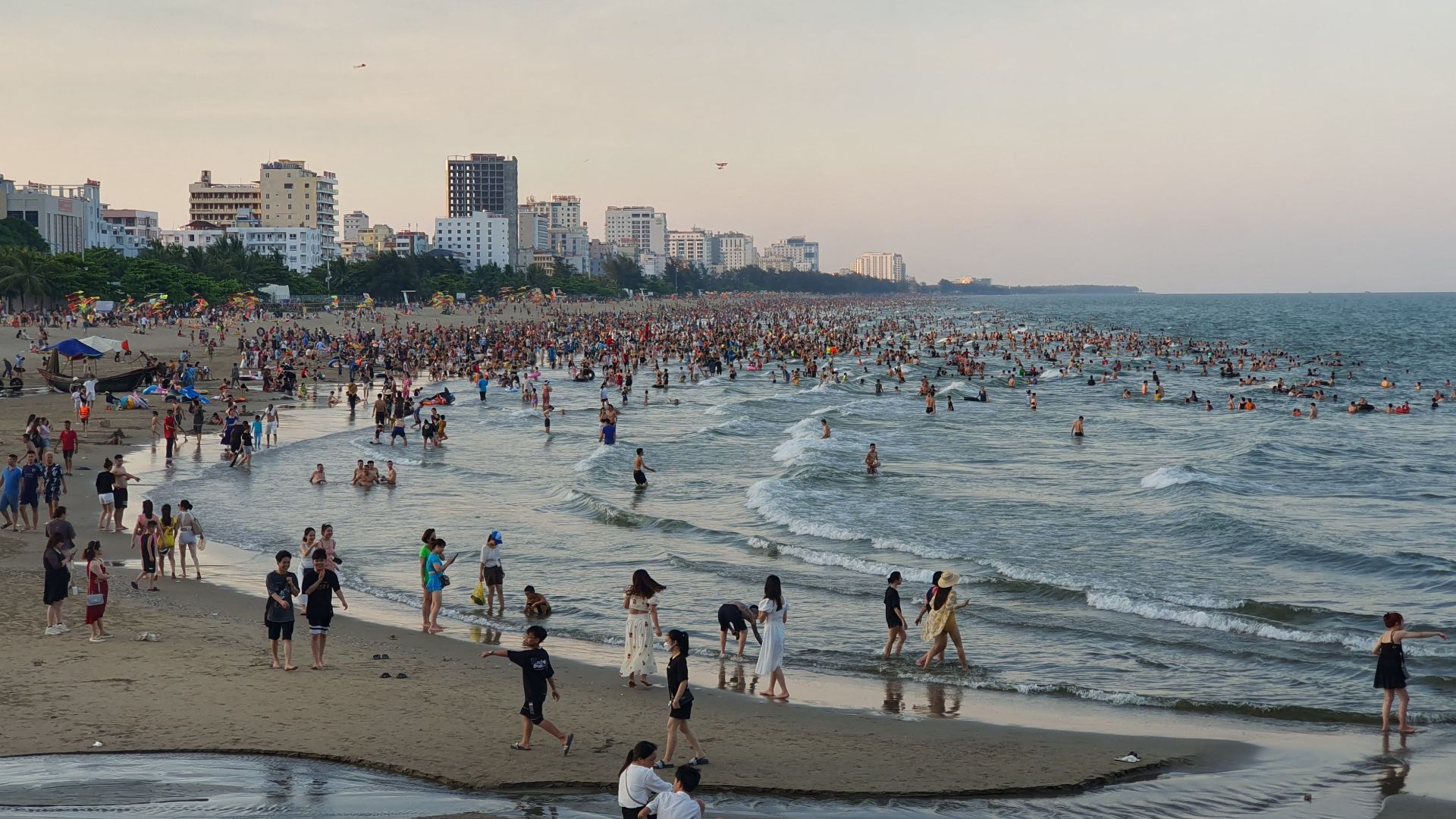 Crowded Sầm Sơn beach in Vietnam with people enjoying the summer by the sea.