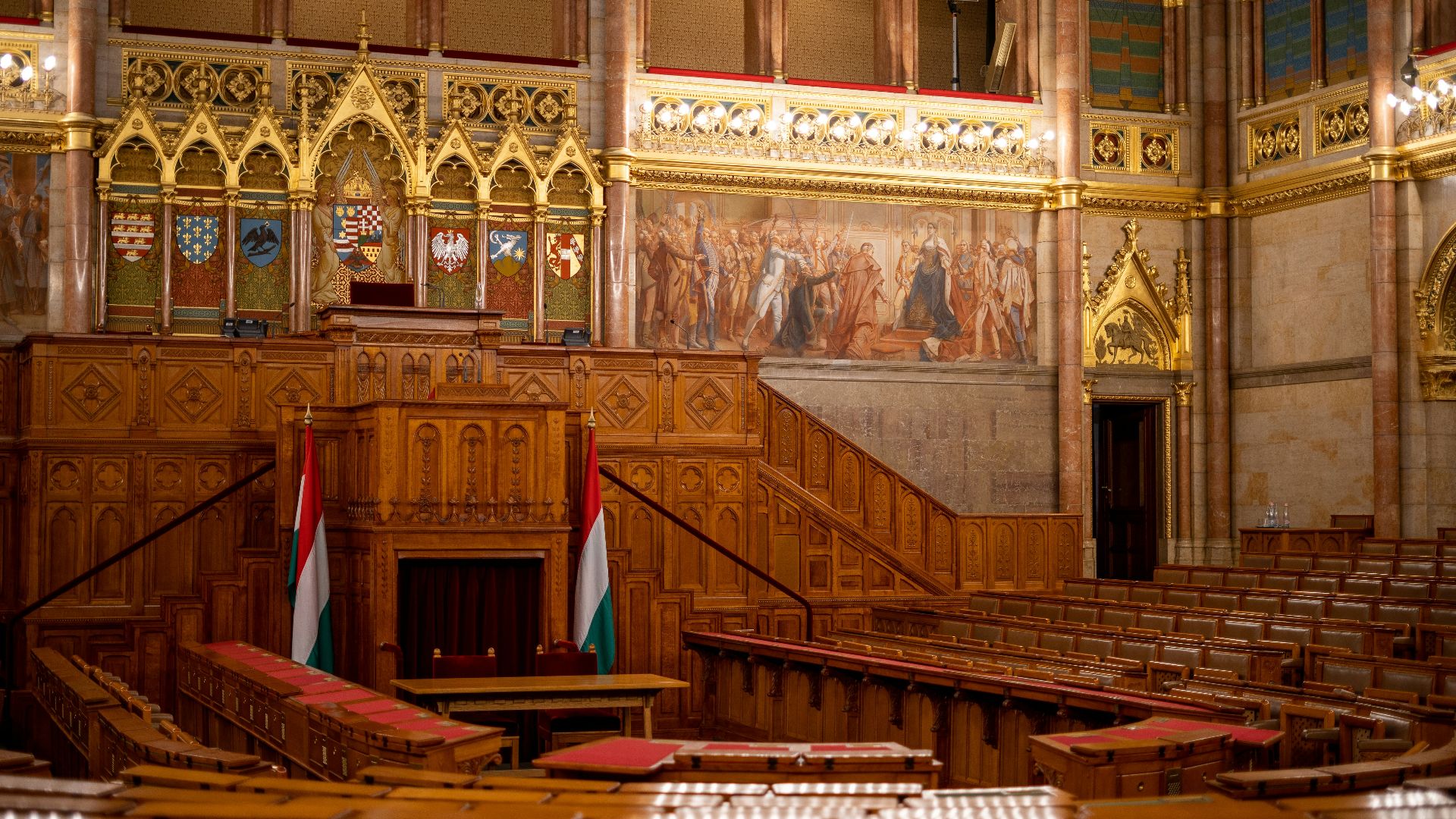 the interior of a large building with wooden pews