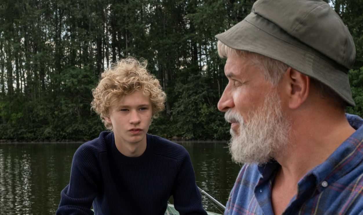 An elderly man and a boy sitting in a boat on a serene lake, enjoying a quiet moment together