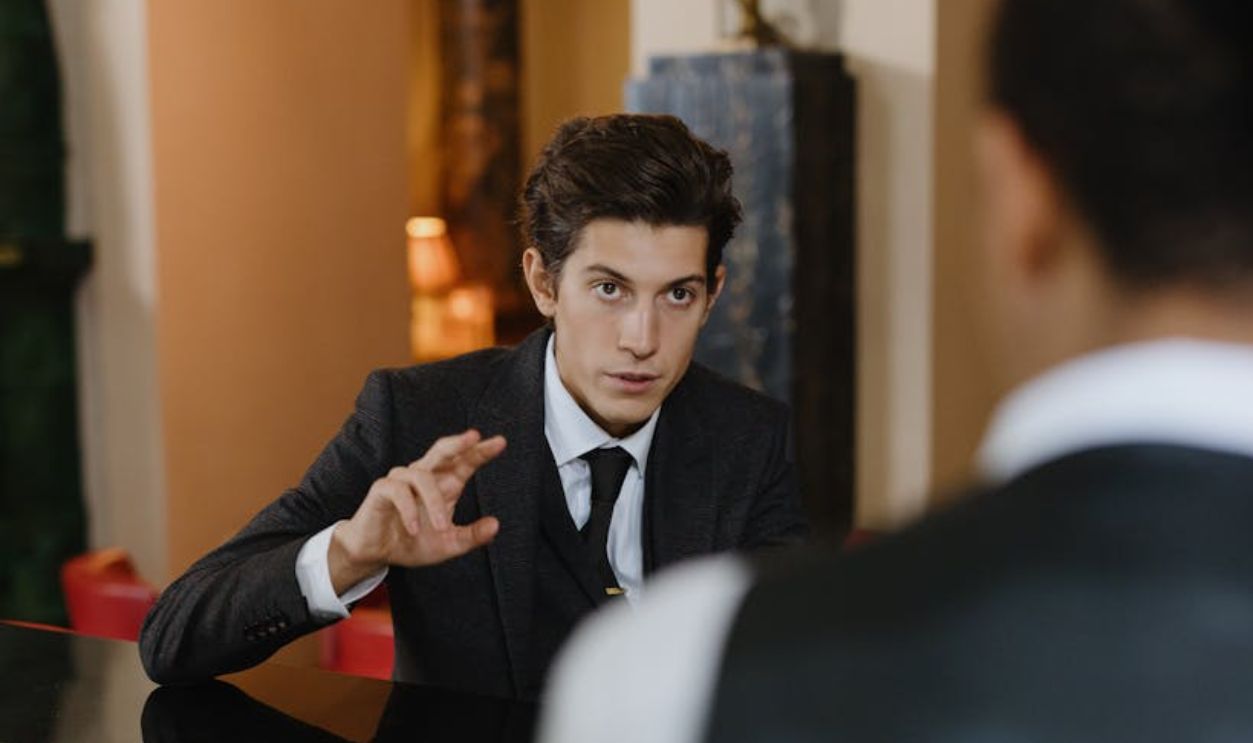 A classy interaction between a gentleman and a waiter at a stylish vintage bar setting
