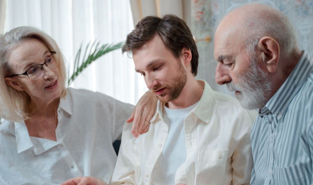 A family looks through a photo album, cherishing memories together indoors