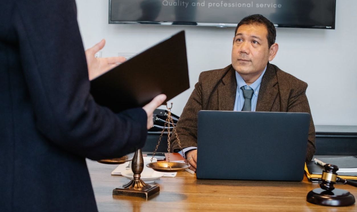 Lawyer attentively listens to a colleague in a professional office setting, discussing a legal case