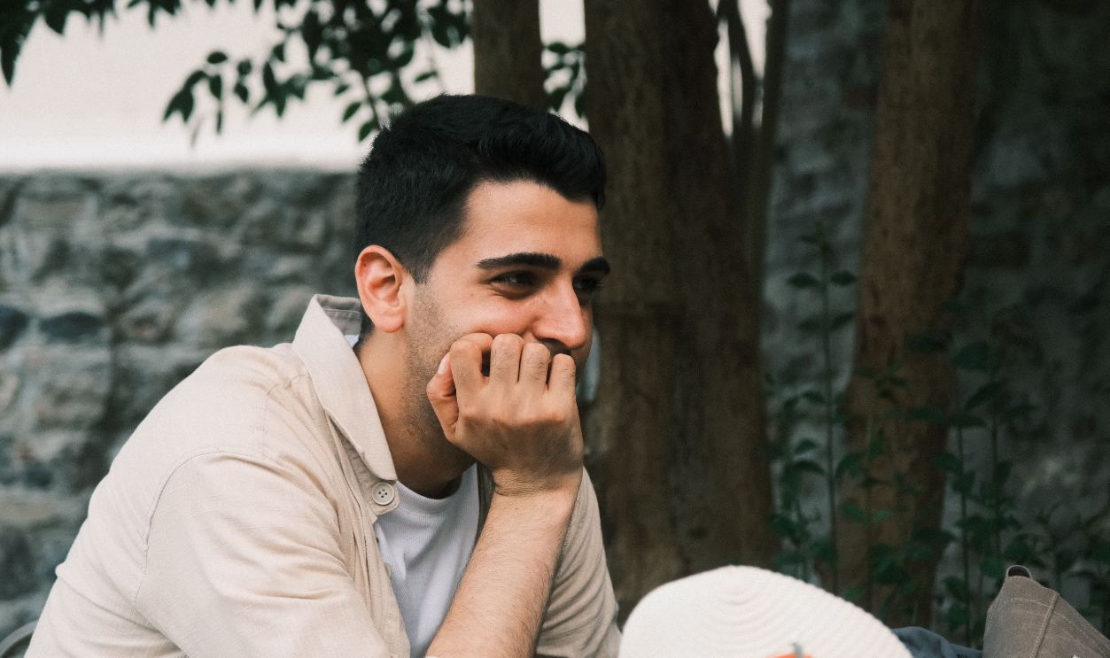 Portrait of a contemplative man relaxing outdoors, surrounded by nature
