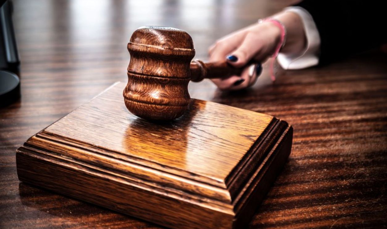 Close-up of a wooden gavel on a judge's desk, symbolizing justice.