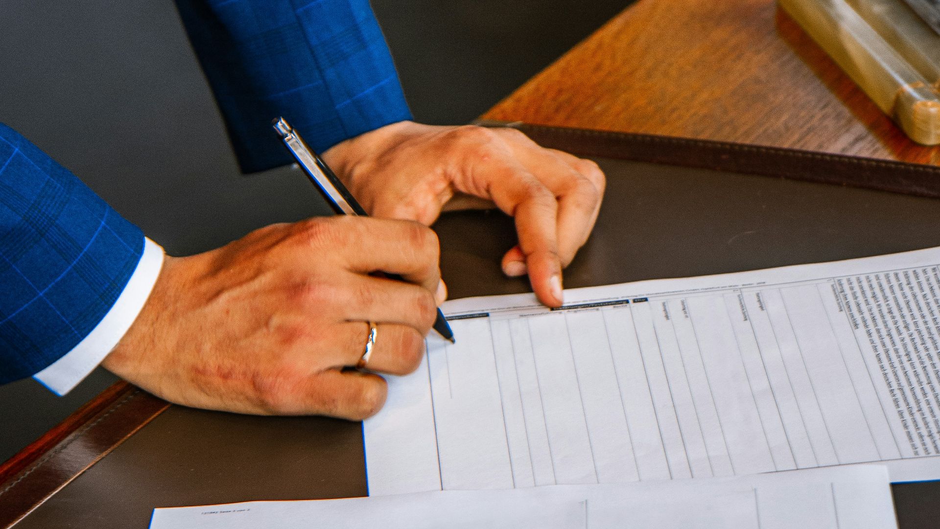 person writing on white form paper