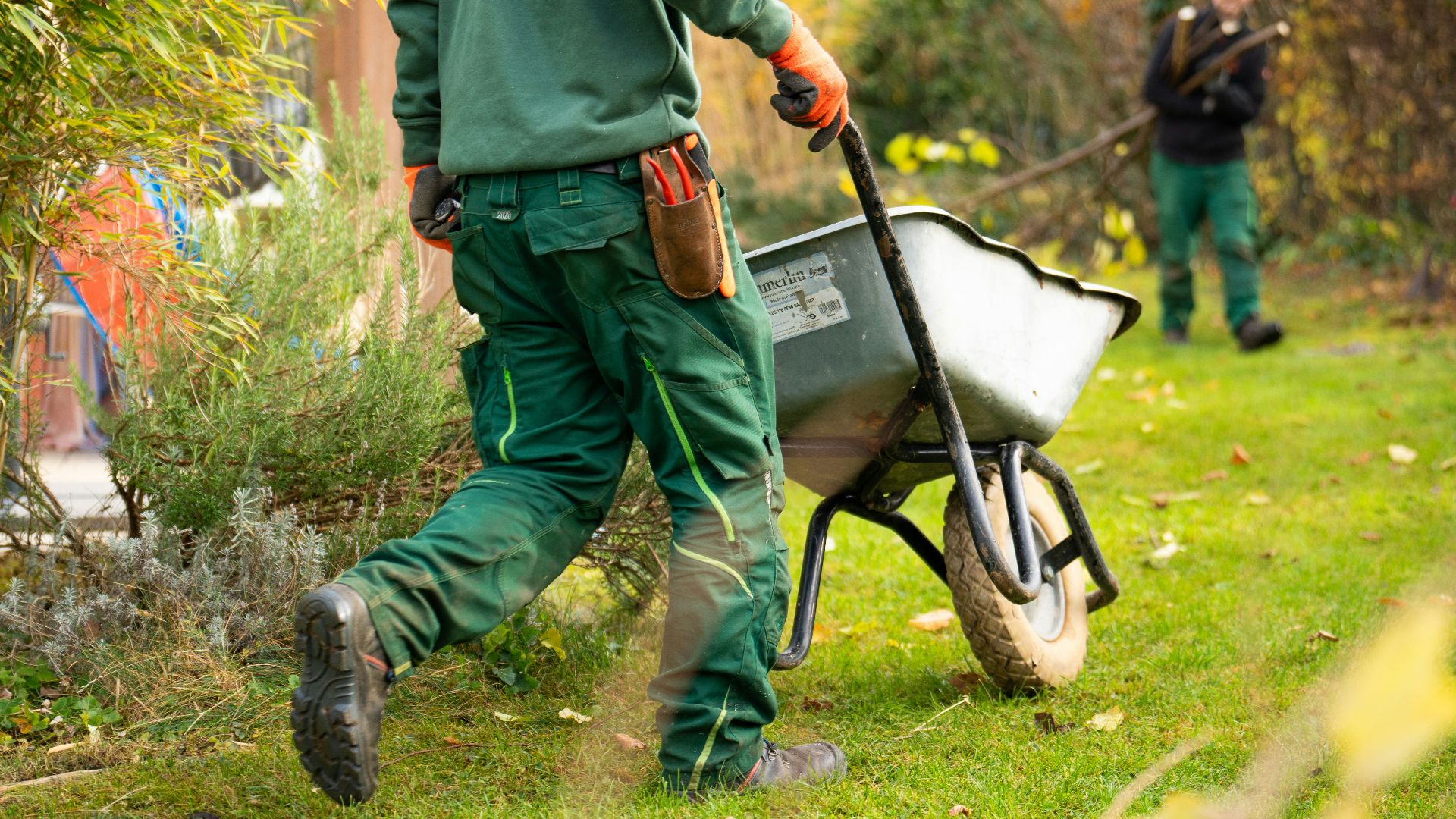 A man pulling a wheelbarrow with a wheel