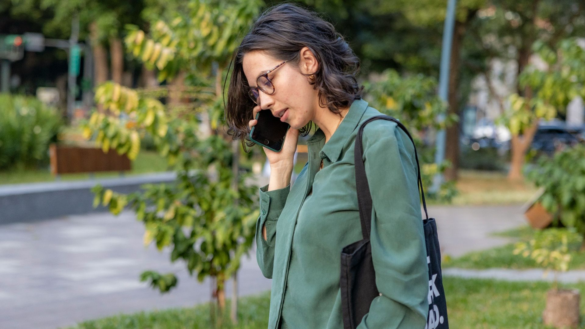 a woman talking on a cell phone in a park