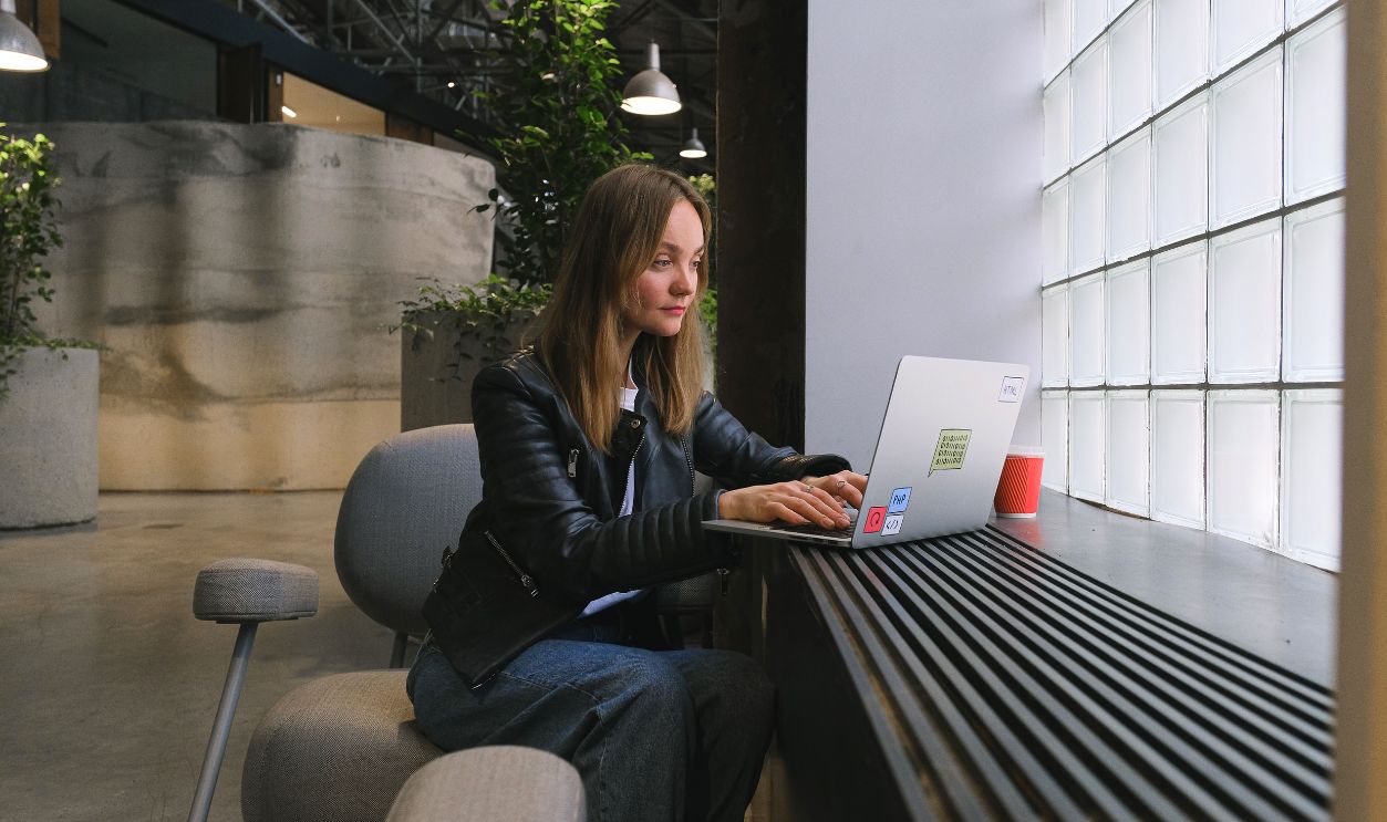Young woman working on a laptop in a stylish modern office with natural lighting