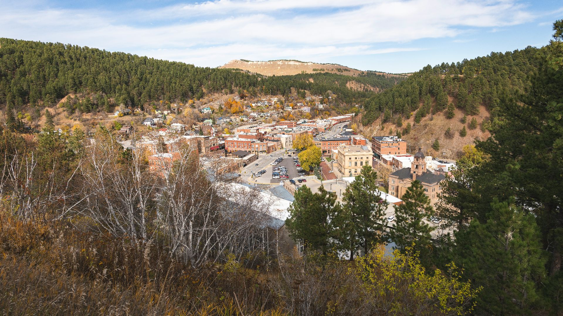 Historic town nestled in a valley with autumn trees.