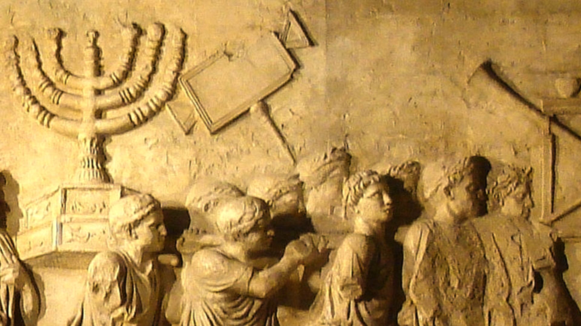 This photograph shows a modern replica of the Arch of Titus relief depicting the spoils of the Jerusalem Temple, including the temple menorah, carried in a triumphal procession through Rome following the Roman conquest of Jerusalem in 70 CE. The replica w
