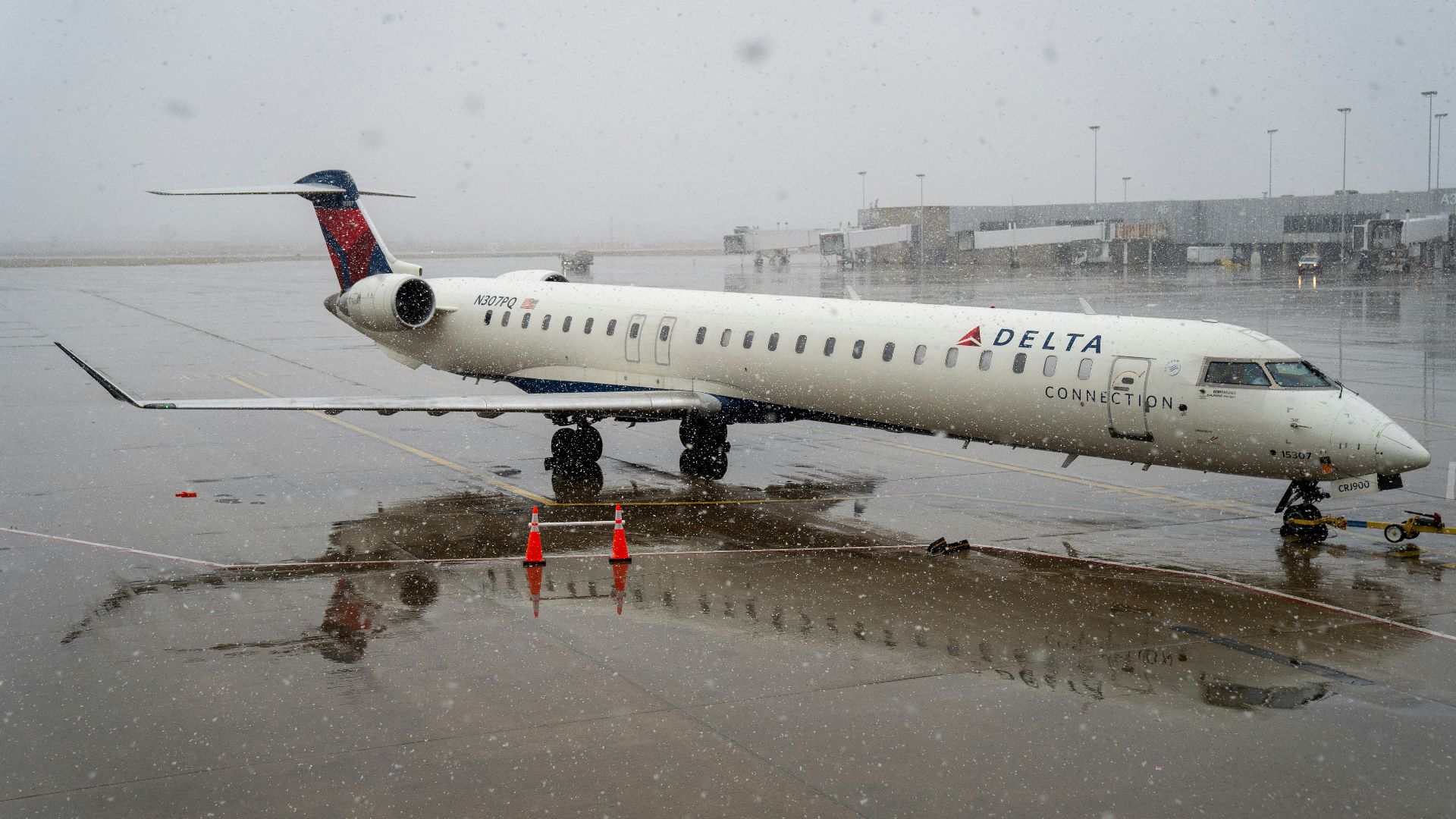a delta airplane is parked on a wet runway