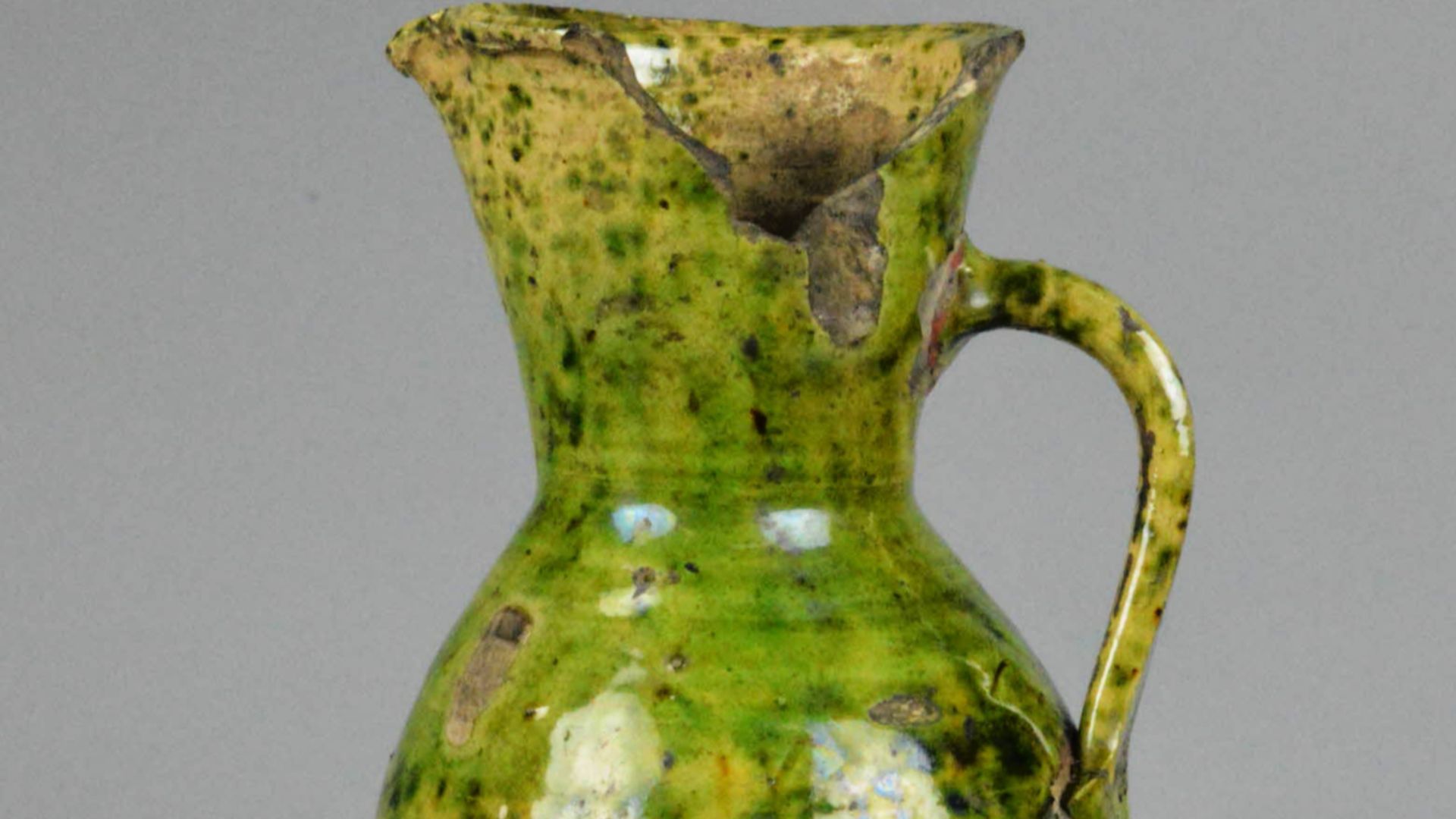 Border ware jug. Tudor green-glaze. Funnel-shaped neck and tall body. Height 23.3 cm