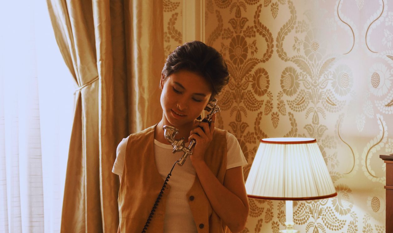 A woman stands in a luxurious bedroom, talking on the phone, showcasing elegant home interior design