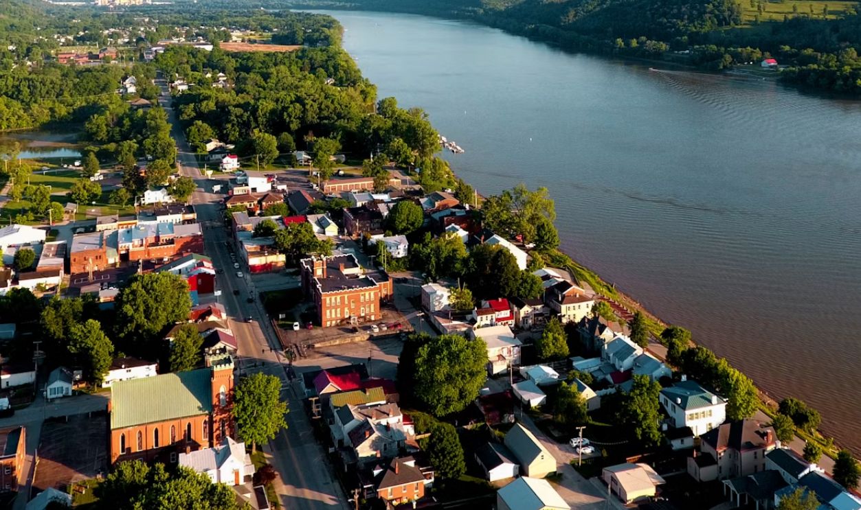 aerial photography of houses near body of water viewing mountain under white and blue sky