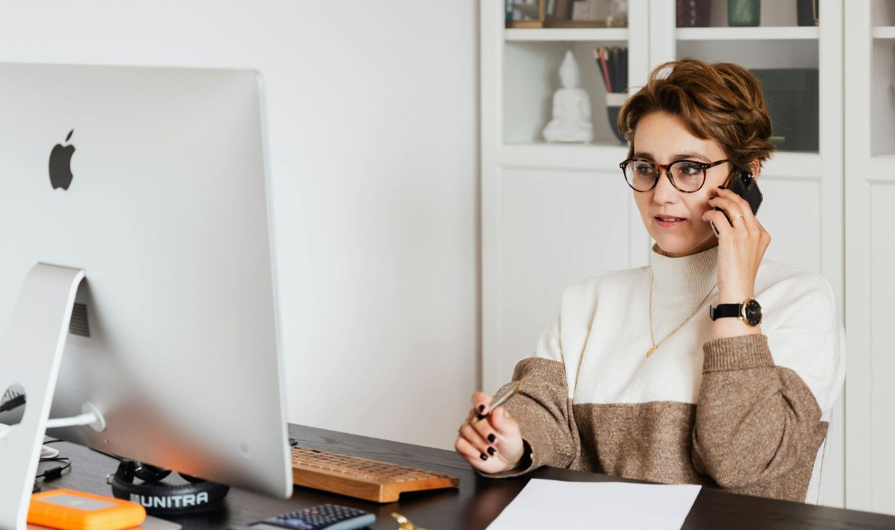 A professional woman in an office on a phone call