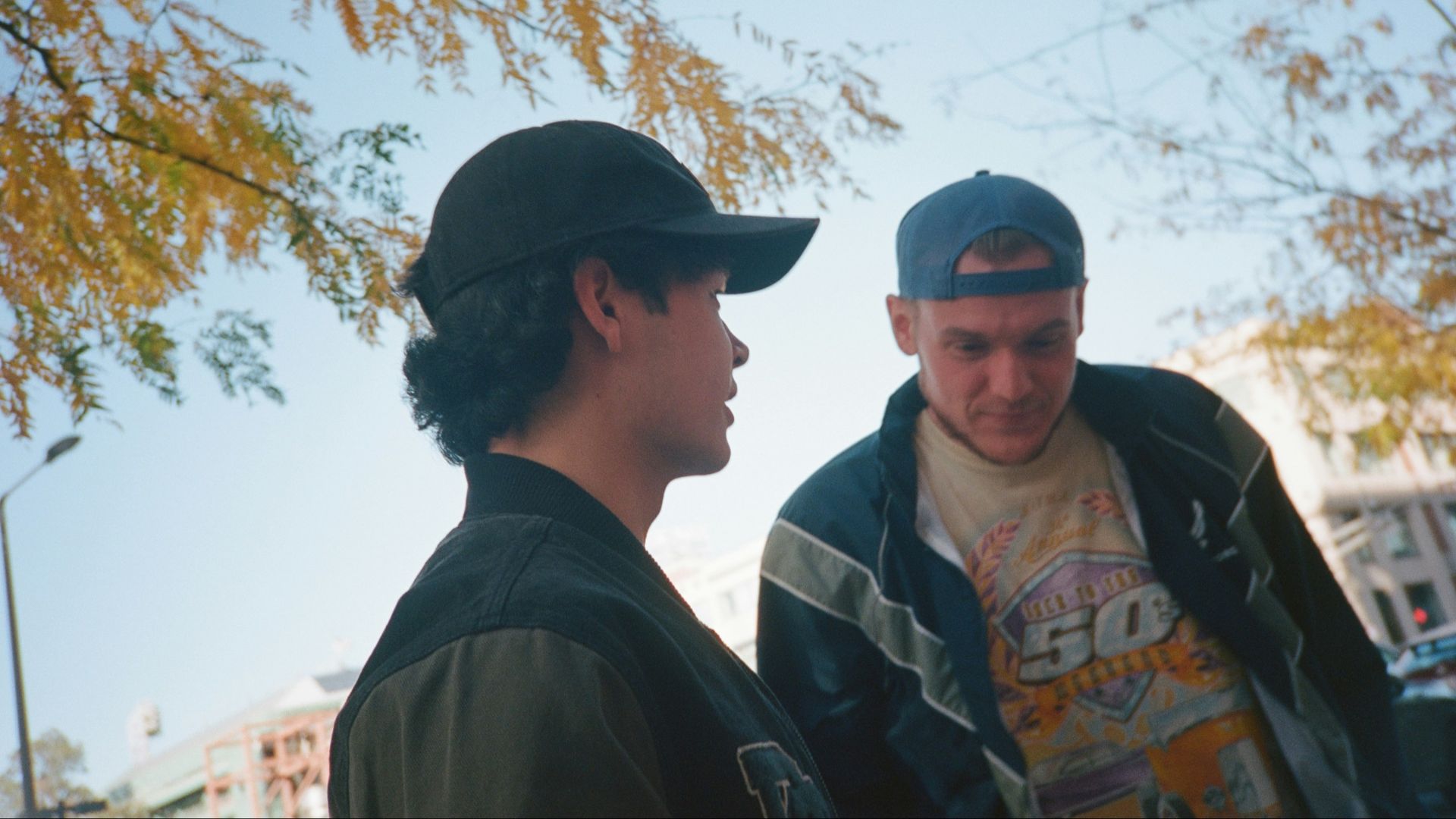 Two men standing next to each other on a street