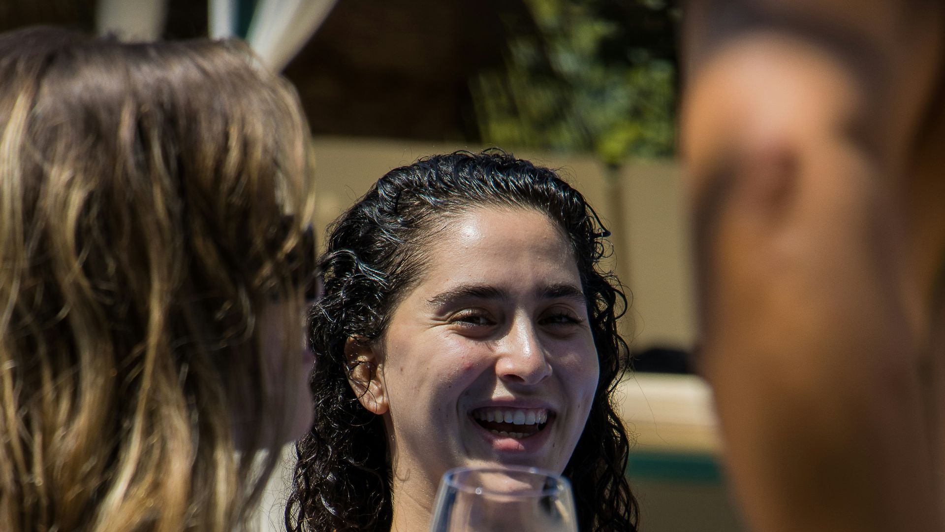 a woman in a bathing suit holding a glass of wine