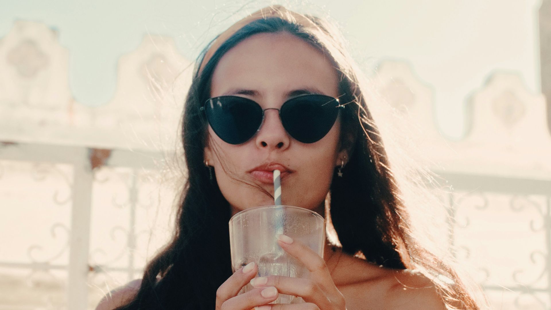 woman sipping straw in glass