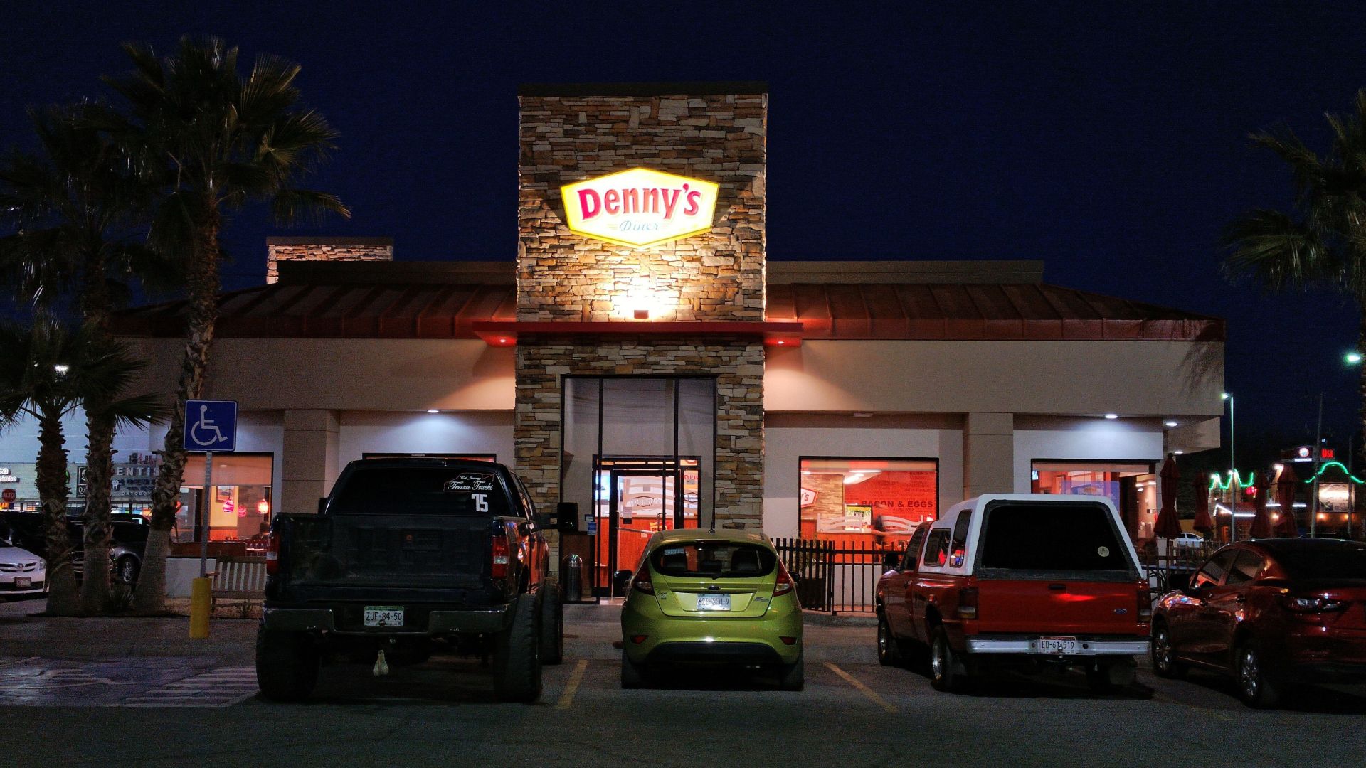 Vista de la fachada de un restaurante Dennys de noche