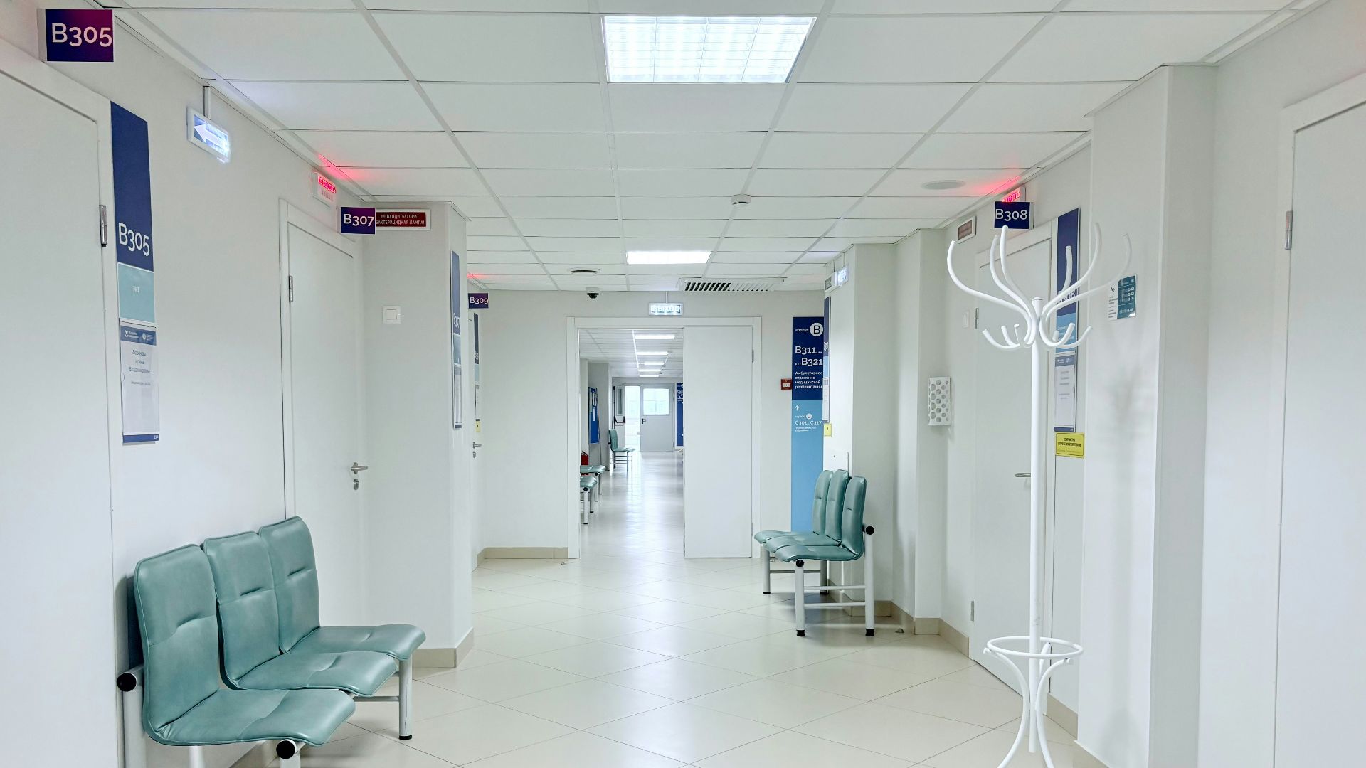 Empty hospital corridor with benches and doors