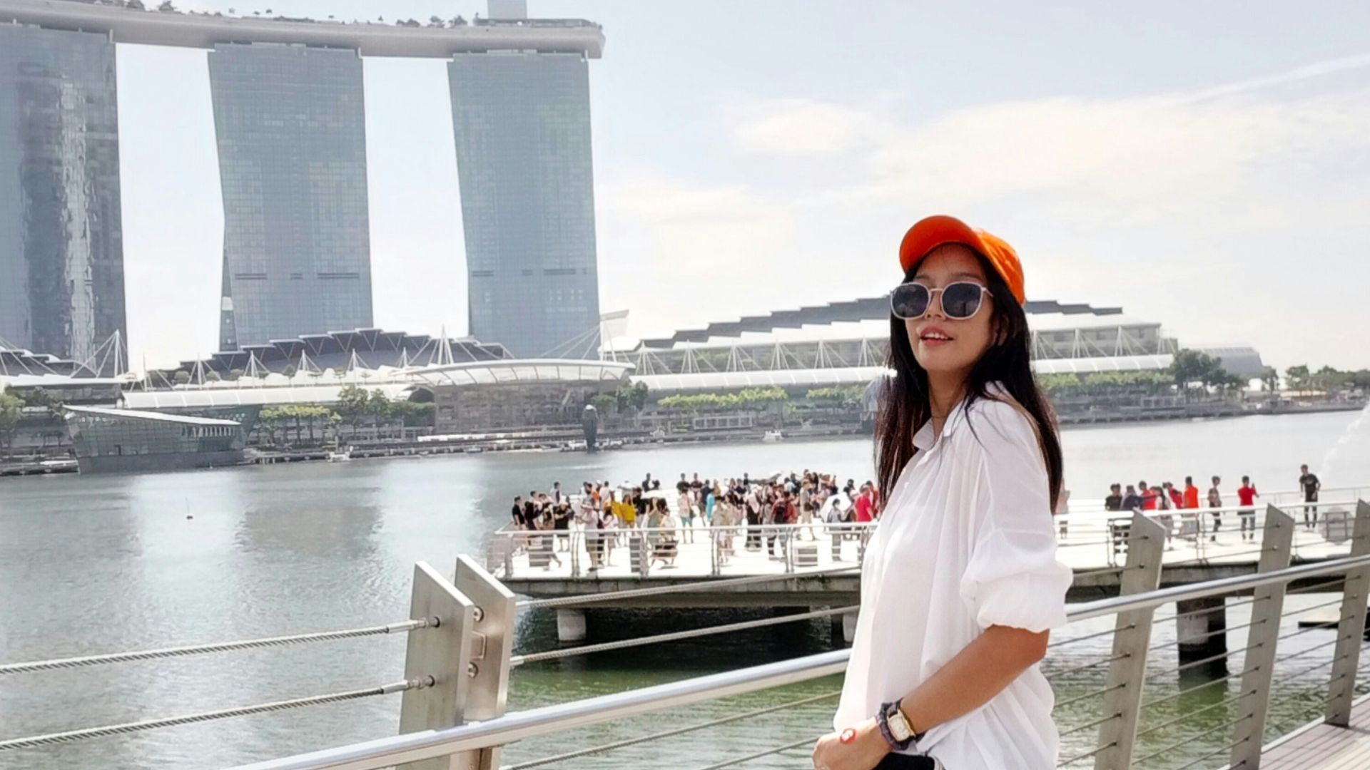 a woman standing on a bridge next to a body of water