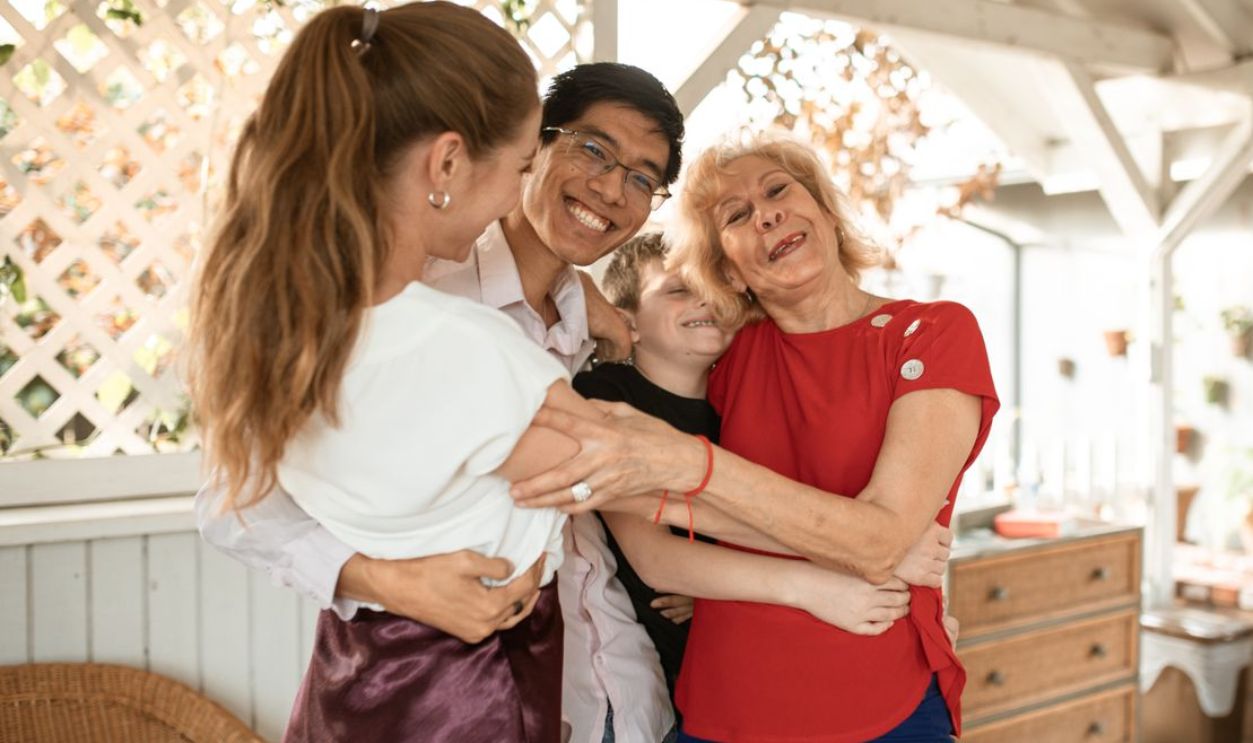 A joyful family group hug with diverse members expressing love and happiness