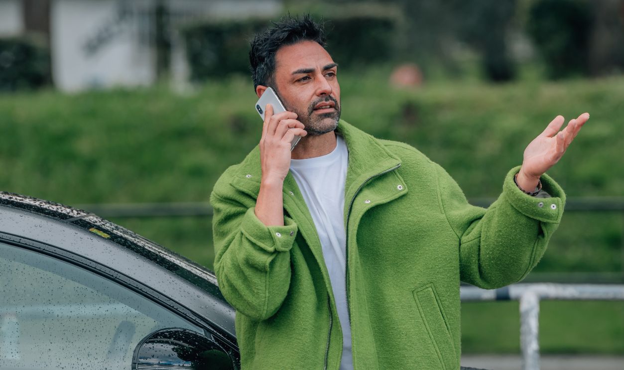 bearded man outdoors with mobile phone in the car