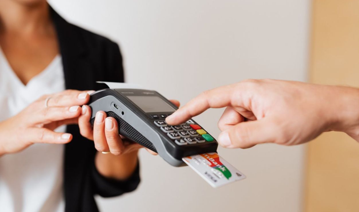 A customer using a contactless payment terminal for secure and cashless transactions indoors.