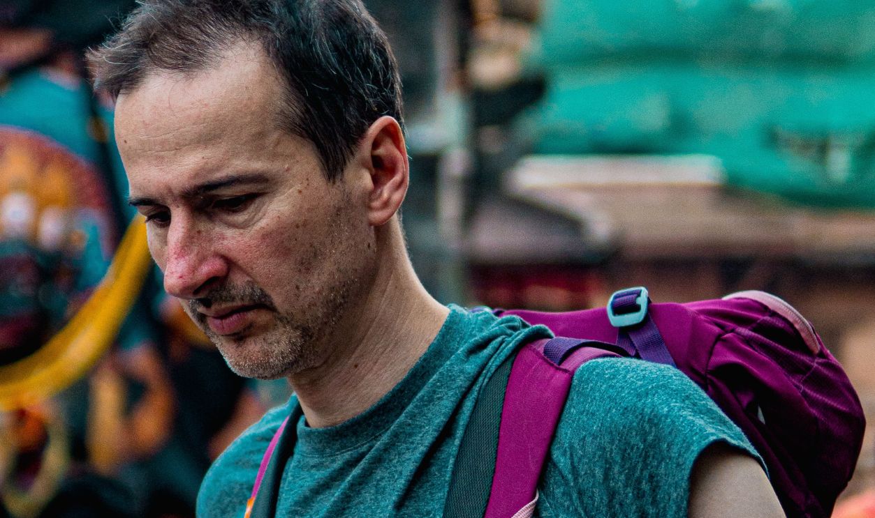 A man with a backpack explores the vibrant and crowded Kathmandu Durbar Square, Nepal.