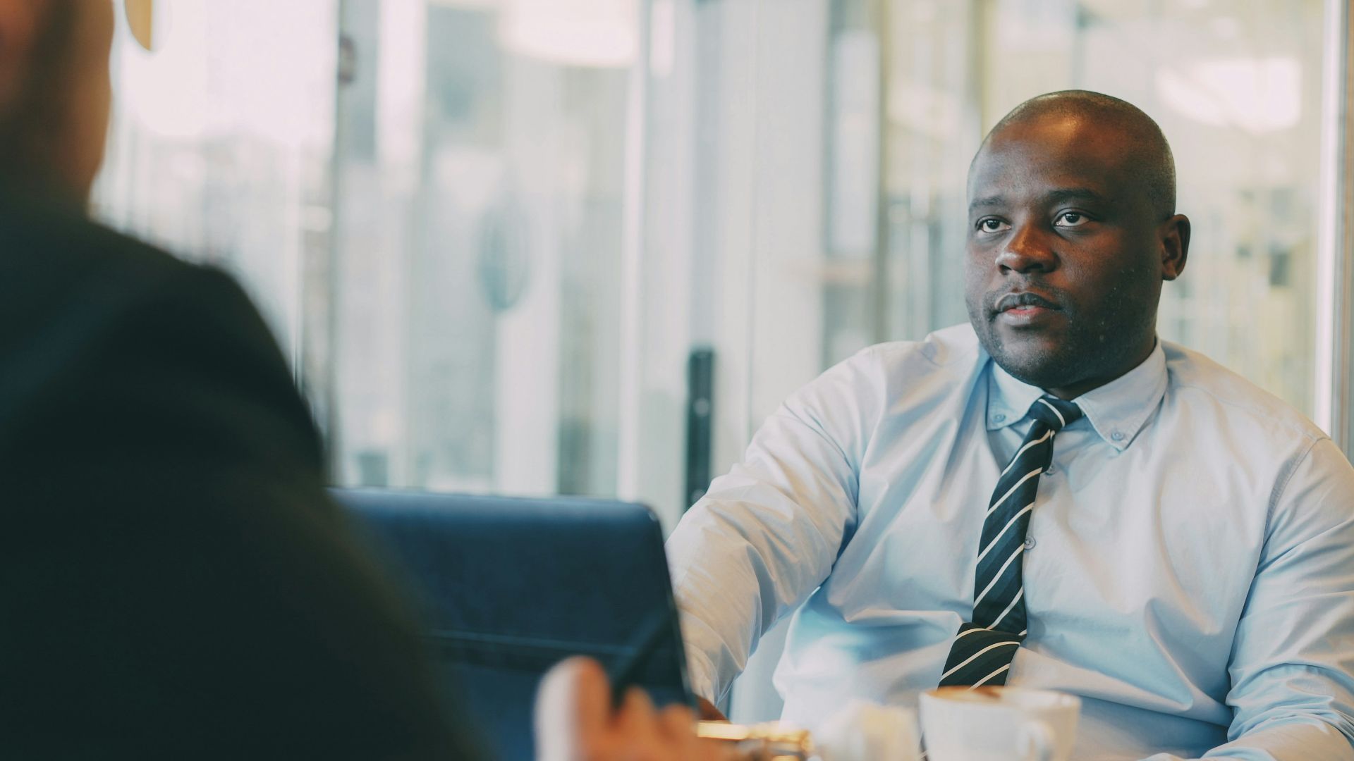 Two businessmen in a meeting with coffee.