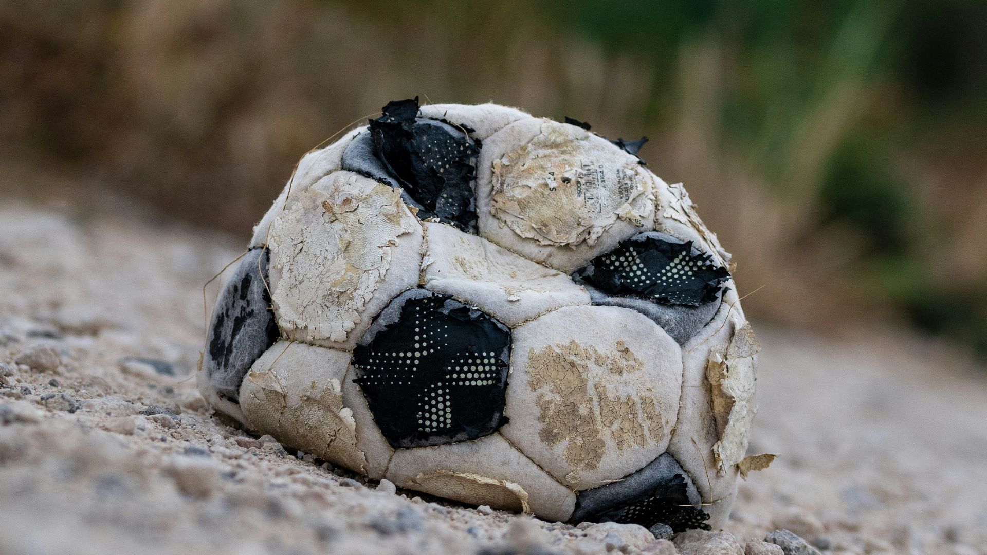 a dirty soccer ball laying on the ground