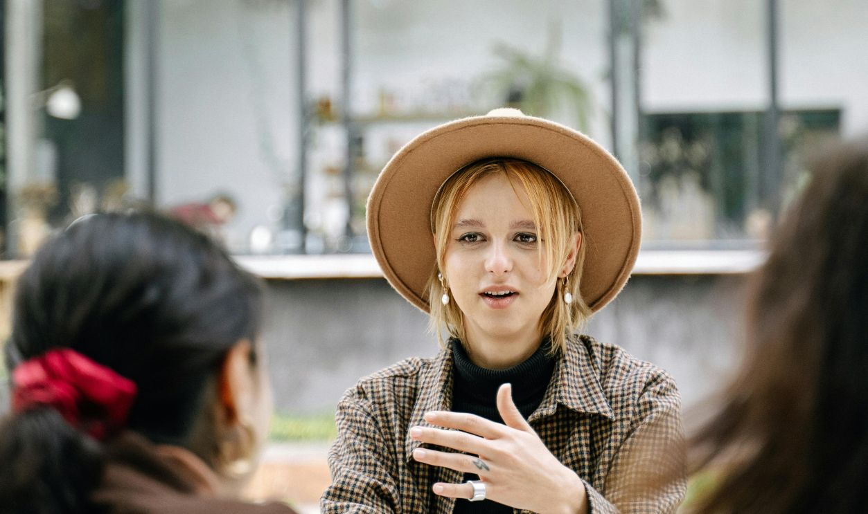 Three women engaged in conversation outdoors, embracing diversity