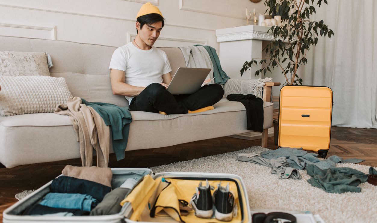 A young man in yellow accessories works on a laptop